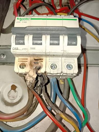 A main switch with a badly overheated, charred and melted terminal — the kind of dangerous fault we're called out to
